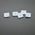 Close-up of the word 'email' formed with letter tiles on a gray surface.